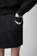 Alice Girls’ Skirt - Girls’ black cotton fleece skirt with diamanté and wings motif on the back.