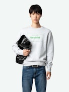Sudadera Simba con Escudo - Sudadera de algodón ecológico de color gris jaspeado, de manga larga, con escudo Studio en la parte delantera.