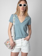 T-shirt Story Fishnet - T-shirt en coton biologique bleu ciel à manches courtes et broderie tête de mort et fleurs au dos.