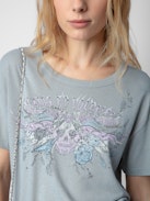 T-shirt Marta Concert Strass - T-shirt grigia a maniche corte con motivi Concert, teschio e ali in strass.