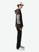 Oliver Cardigan - Long-sleeved brown knitted zip-up cardigan with hood, Dinosaur intarsia motif on back and "Art Is Truth" message on right sleeve.