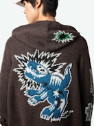 Oliver Cardigan - Long-sleeved brown knitted zip-up cardigan with hood, Dinosaur intarsia motif on back and "Art Is Truth" message on right sleeve.
