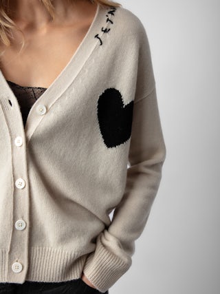 Mirka Cashmere Cardigan - A luxurious blend of softness and Parisian flair. Crafted from 100% premium cashmere, this ecru-hued cardigan offers a cozy yet lightweight feel, perfect for layering across seasons. The design features a contrasting black heart motif on the chest, complemented by intarsia jacquard slogans "Je t'aime" and "Amour" that add a touch of romantic charm.​