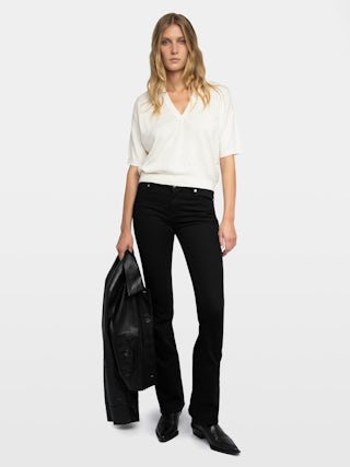 Wully Diamanté Sweater - Cozy meets cool with a touch of sparkle. This ultra-soft white rhinestone sweater wraps you in effortless warmth without losing its edge. Shimmering crystal accents trace the neckline and scatter across the front, delivering refined, rock-chic glamour. A clean V neck and short sleeves let the white rhinestone sweater layer under leather or stand alone over denim, carrying laid-back polish from crisp mornings to late-night sets.