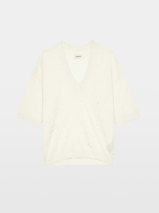 Wully Diamanté Sweater - Cozy meets cool with a touch of sparkle. This ultra-soft white rhinestone sweater wraps you in effortless warmth without losing its edge. Shimmering crystal accents trace the neckline and scatter across the front, delivering refined, rock-chic glamour. A clean V neck and short sleeves let the white rhinestone sweater layer under leather or stand alone over denim, carrying laid-back polish from crisp mornings to late-night sets.