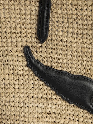 Mini Wings Basket Bag - Small raffia basket with leather handles, adorned with wings.