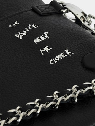 Pochette Rock - Pochette en cuir grainé imprimé Graffiti à double chaîne cuir et métal et ailes ornées de strass.