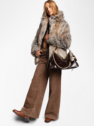 Jim Vintage Patent Bag - Soft leather bag with vintage effect adorned with a chain and a rhinestone wing.