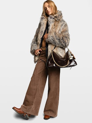 Jim Vintage Patent Bag - Soft leather bag with vintage effect adorned with a chain and a rhinestone wing.