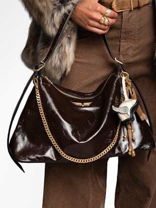 Jim Vintage Patent Bag - Soft leather bag with vintage effect adorned with a chain and a rhinestone wing.