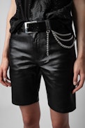 Gürtel Rock Chain Glossy Wild - Schwarzer Gürtel aus glänzendem Leder mit Python-Effekt, dreifacher Kette und Flügel-Charm für Damen.