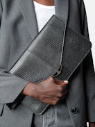 Borderline Pouch - Women’s envelope clutch in shiny black leather with embossed iguana, khaki suede interior, and black lacquered wings on the clasp.
