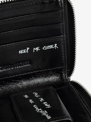 Sunny Purse - Vintage-effect patent leather coin purse with medallion and signature metal wings.