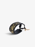 Pulsera Lenny - Brazalete negro de cuero anudable con alas doradas.