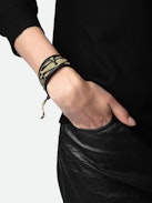 Pulsera Lenny - Brazalete negro de cuero anudable con alas doradas.