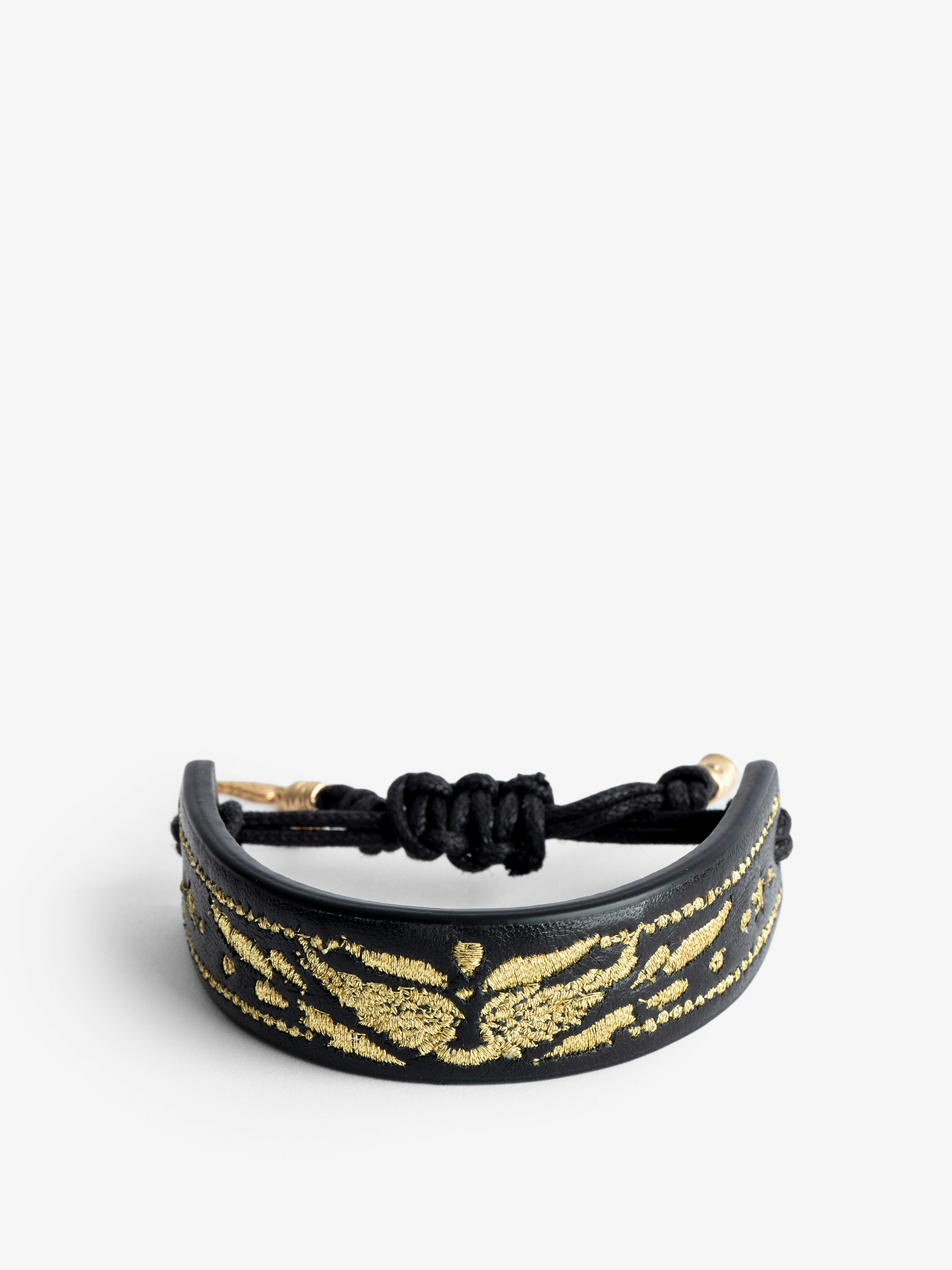 Bracelet Lenny  - Bracelet manchette en cuir noir Voltaire Vice à cordon de serrage orné d'ailes dorées.