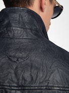 Lederjacke Loumy - Puristische Jacke aus geknittertem Leder mit Reißverschluss, Paspeltaschen und geprägter Flügel-Signatur auf der Rückseite.