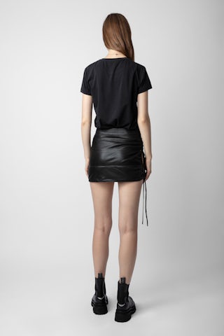 Jupe Jylo Cuir - Jupe courte en cuir noir à liens de serrage et ouvertures.