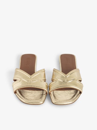 Azora Mules - A harmonious blend of edgy design and luxurious craftsmanship. These mules feature a metallic crinkled leather exterior, exuding a bold yet sophisticated allure. The embossed signature wings add a distinctive touch, embodying the brand's rebellious spirit. Designed with a square toe and crossover strap at the toe, they offer both style and comfort.