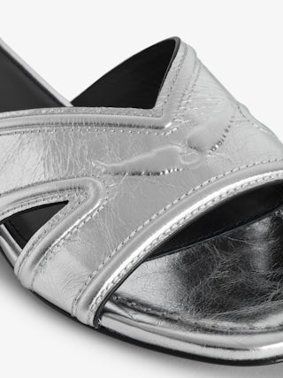 Azora Mules - A harmonious blend of edgy design and luxurious craftsmanship. These mules feature a metallic crinkled leather exterior, exuding a bold yet sophisticated allure. The embossed signature wings add a distinctive touch, embodying the brand's rebellious spirit. Designed with a square toe and crossover strap at the toe, they offer both style and comfort.