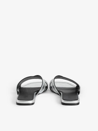 Azora Mules - A harmonious blend of edgy design and luxurious craftsmanship. These mules feature a metallic crinkled leather exterior, exuding a bold yet sophisticated allure. The embossed signature wings add a distinctive touch, embodying the brand's rebellious spirit. Designed with a square toe and crossover strap at the toe, they offer both style and comfort.