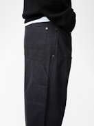 Perry Pants - Black worker-style pants with front patch and rivet details.