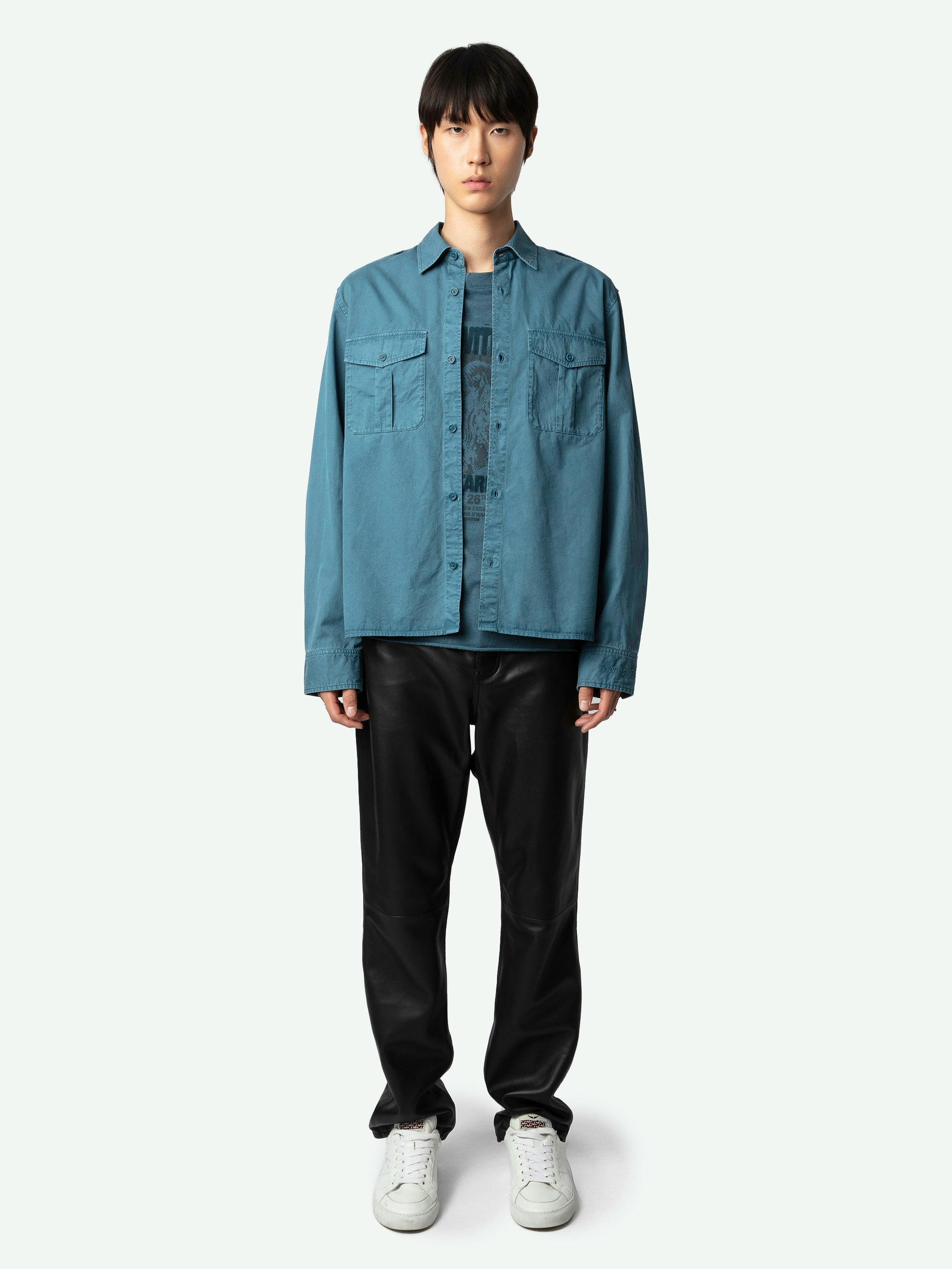 Hemd Taskal - Langärmeliges, blaues Military-Hemd aus Bio-Baumwolle mit Schulterklappen und „Art Is Truth“-Stickerei am Handgelenk.