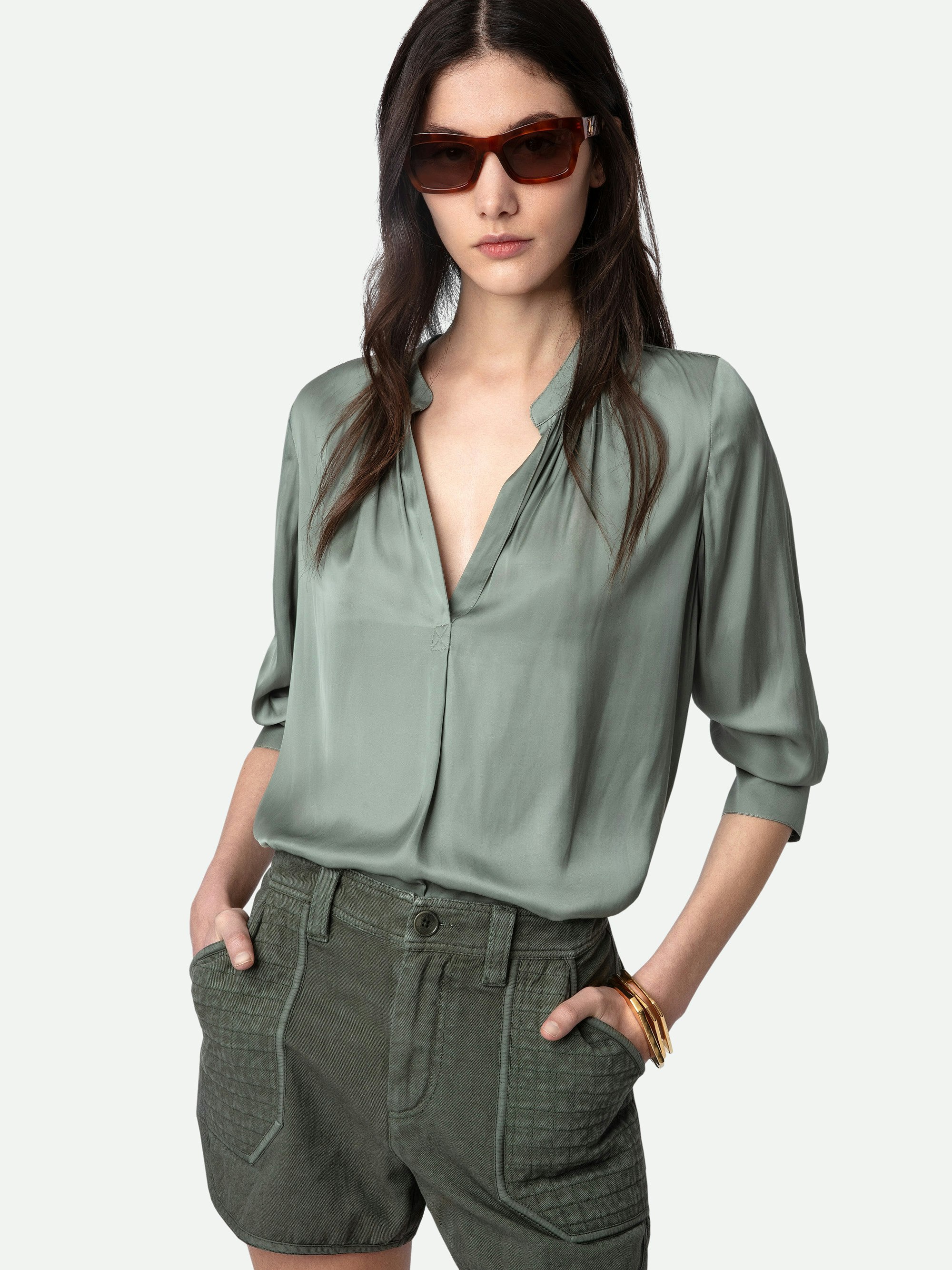 Blusa de Satén Tink - Blusa de satén en color gris con cuello abierto, mangas largas y detalles fruncidos.