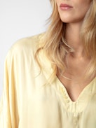 Blusa Tonastir Raso - Blusa in raso giallo chiaro con collo serafino e maniche lunghe.