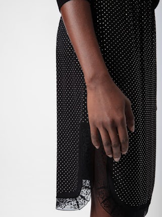 Jupe Jozy 100% Soie - Jupe mi-longue esprit lingerie en soie noire à fente, strass et bords en dentelle.