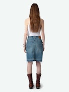 Jupe Jingle Denim - Jupe courte en denim délavé bleu à poches, détails tressés et bords bruts.
