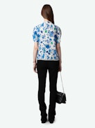 Top Tiffiny - Top de crepé en tono crudo con estampado floral Garden Flowers, cuello y bajo decorados con encaje y botones joya con strass en el lado izquierdo.