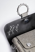 Kate Sparkle Wallet Bag - Shimmer with effortless elegance with the Kate Sparkle Wallet Bag, a dazzling statement piece designed for versatility. Crafted in sparkling silver, this compact yet chic bag features a signature studded metal ring and an engraved flap inspired by Kate Moss. Wear it on your shoulder with the removable chain strap or slip it into a larger bag as a sleek wallet. A must-have sparkle wallet that blends fashion and function seamlessly.