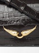 Le Zazi Croco Tasche - Kleine Tasche aus Leder mit Kroko-Effekt, verstellbarem Schulterriemen und charakteristischen Flügeln.