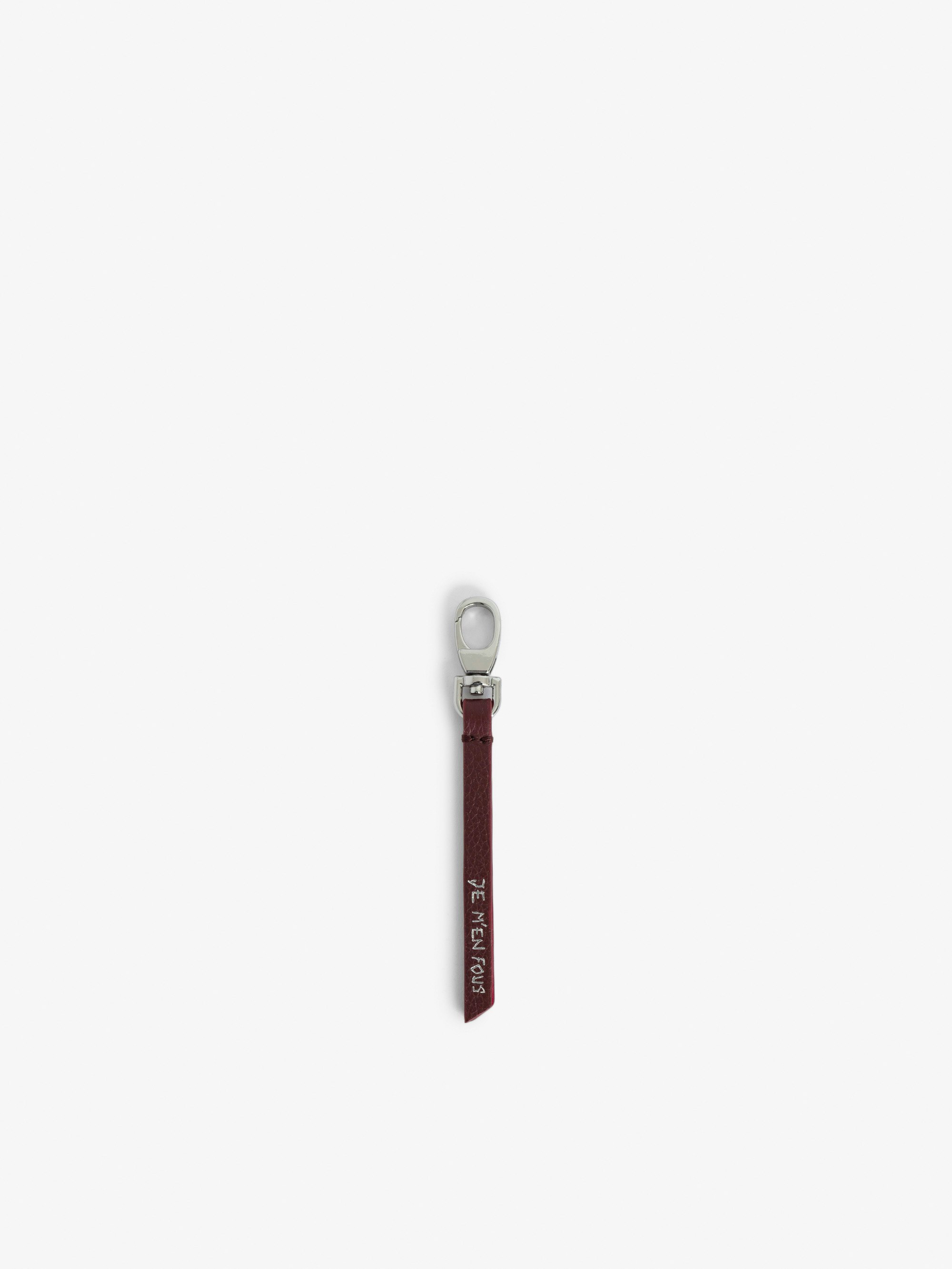 Schlüsselanhänger Love Link - Schlüsselanhänger mit Riemen aus genarbtem Leder mit Schriftzug „Je m'en fous“.