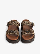 Mules Ride - Leopard-effect leather mules with adjustable strap, adorned with a signature buckle and wing charm.