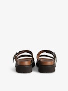 Mules Ride - Leopard-effect leather mules with adjustable strap, adorned with a signature buckle and wing charm.