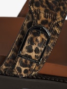Mules Ride - Leopard-effect leather mules with adjustable strap, adorned with a signature buckle and wing charm.